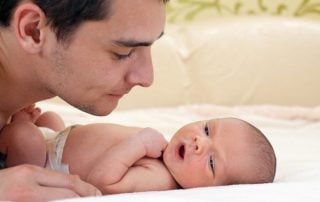 Man crouching down over baby