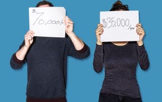 Man holding a sign which reads $70,000/yr and woman holding a sign reading $35,000/year