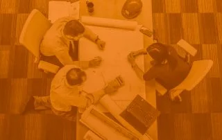 Overhead shot of two men and one woman overlooking strategy