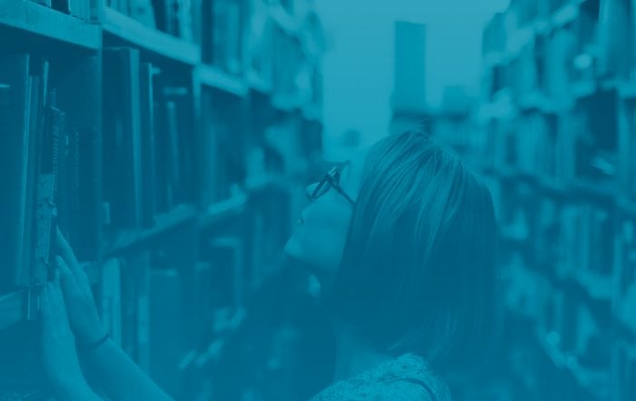 Woman searches through library stacks