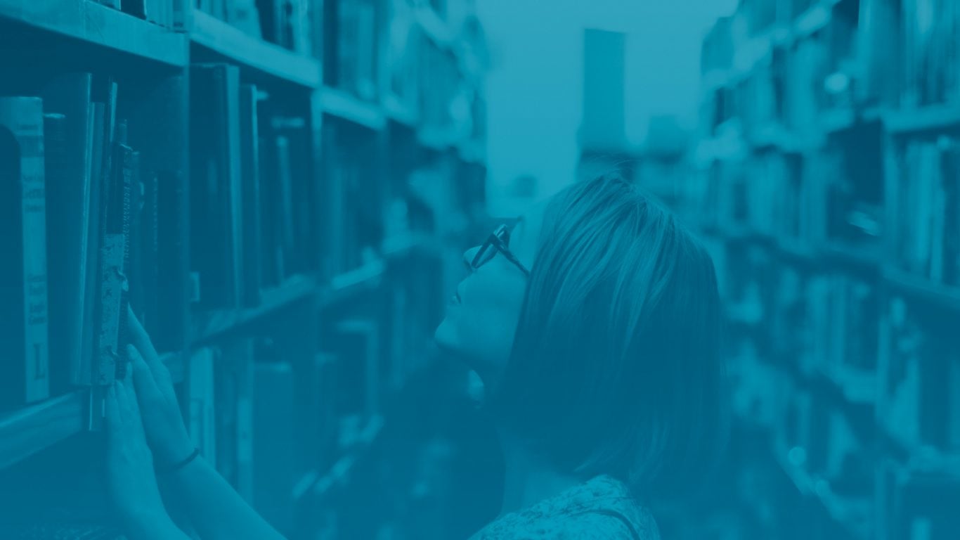 Woman searches through library stacks