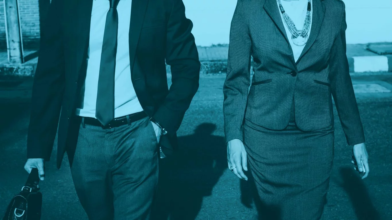 A mid shot of a man and woman in a suit walking