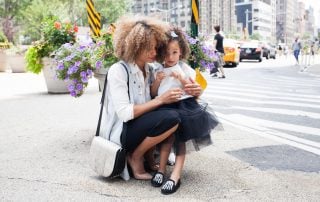 Woman kneeling to hug her daughter