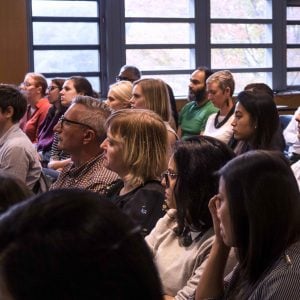 Group of seated attendees look up to event