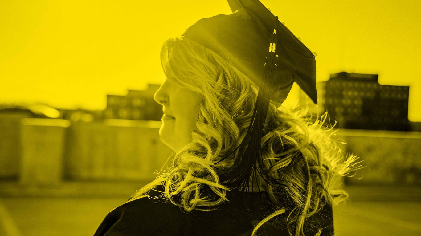 Woman staring into sky wearing convocation hat