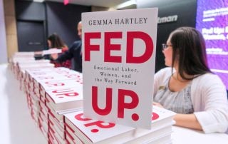 Cover of book "Fed Up" stacked on event registration table