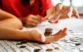 Counting and stacking coins on the palm of a hand