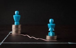 A male and female chess piece place on a stack of coins, with the male token raised higher