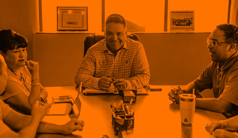 Three colleagues sat at end of board table