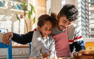 Father cooking with daughter at kitchen table