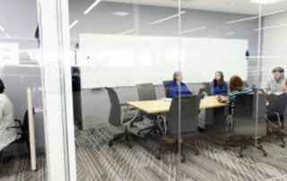 Exterior shot of boardroom with four members sitting inside