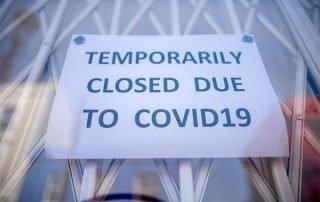 Window sign reading "TEMPORARILY CLOSED DU TO COVID19"