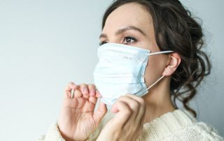 Closeup of woman placing facemask on