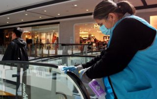 Woman cleaning escalator hand rail