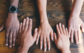 Multi racial hands spread across a table