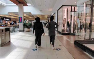 Two women walking in an mall hallway