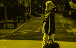 Woman walking across the street with cellphone in hand