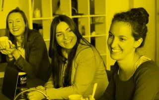 three women sat at desk