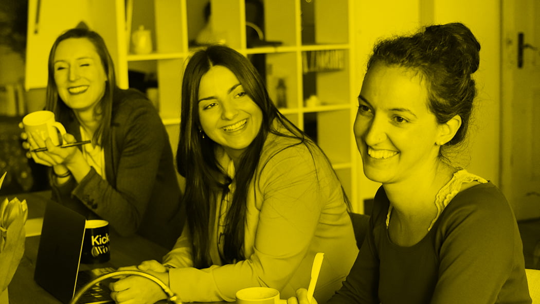 three women sat at desk