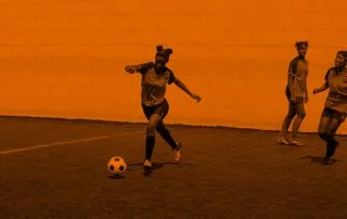 Three girls playing soccer