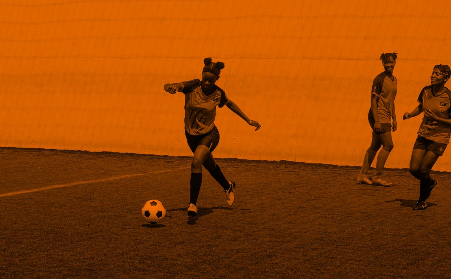 Three girls playing soccer