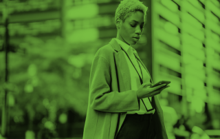 Woman in business wear looking down at her phone