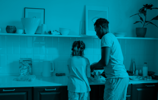 A man and child wash dishes together