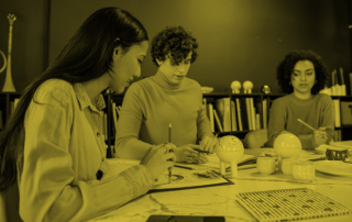 three people sitting across a desk having a meeting
