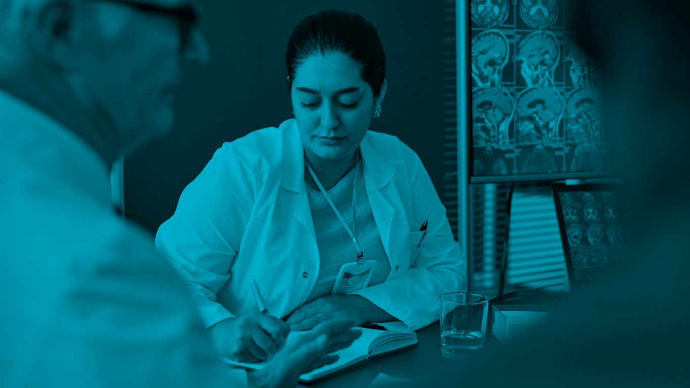 A woman doctor writes notes in front of two men colleagues.